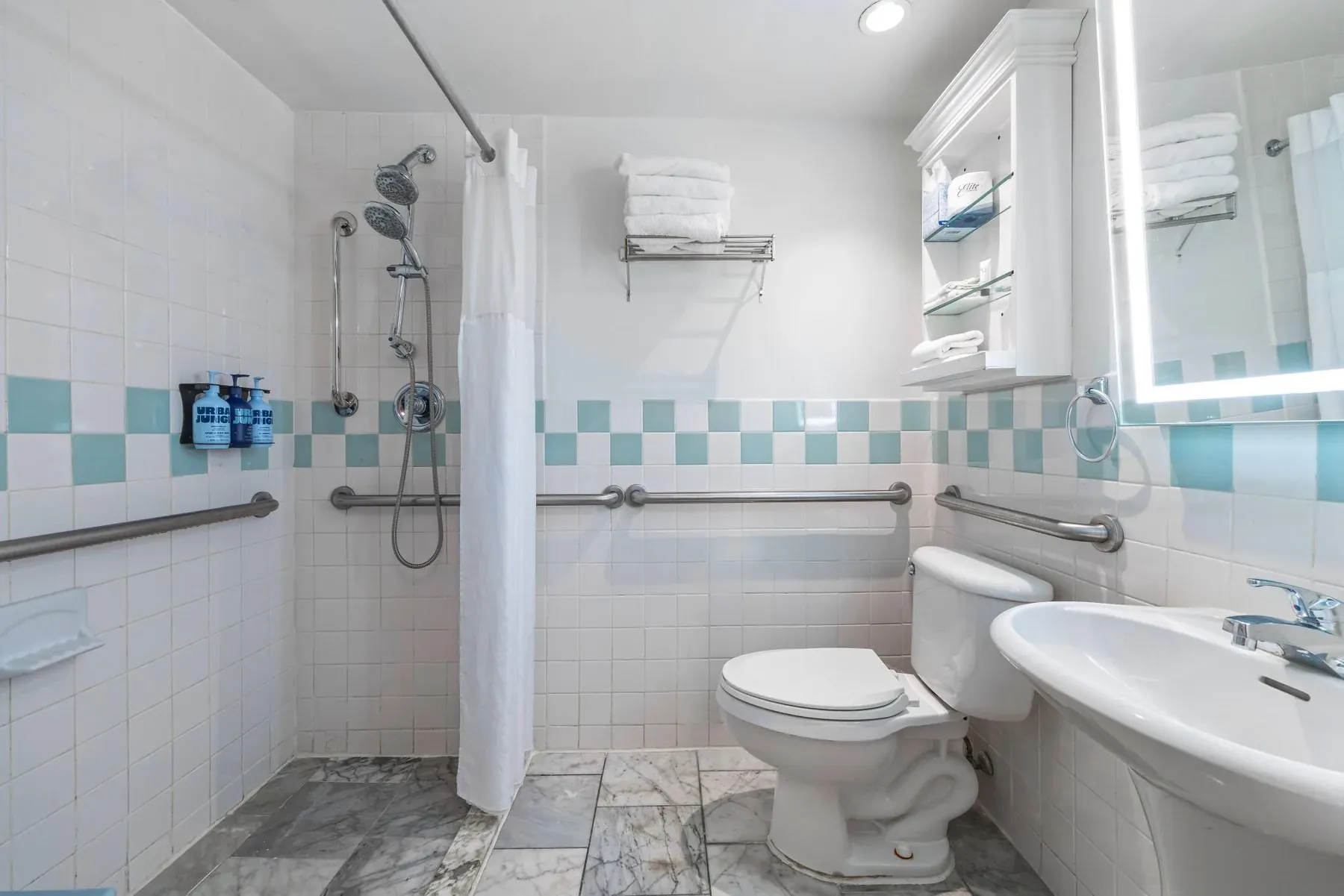 The accessible bathroom, grab bars beside the toilet and a roll-under basin