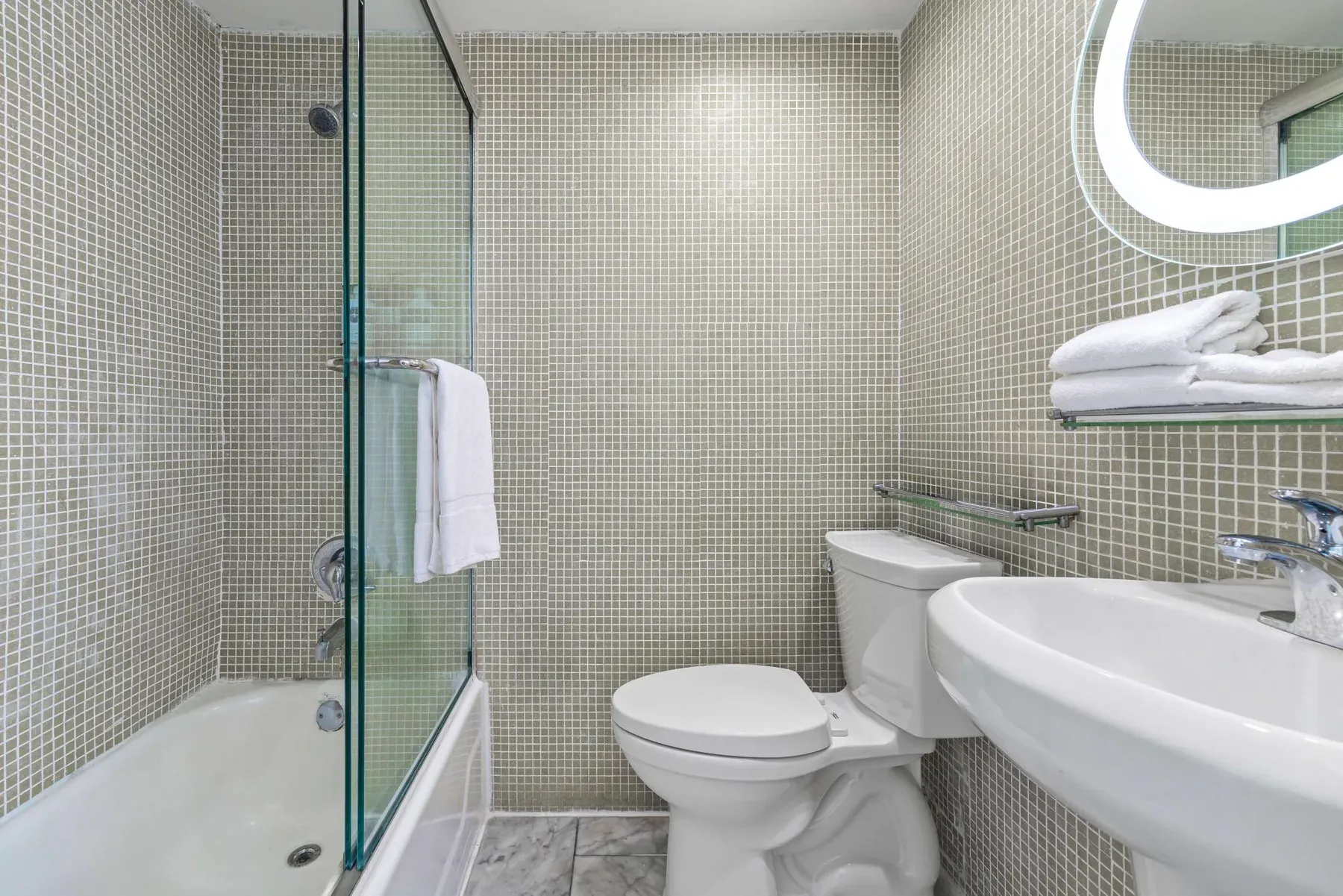 The bathroom, mosaic tile, glass bath screen and basin