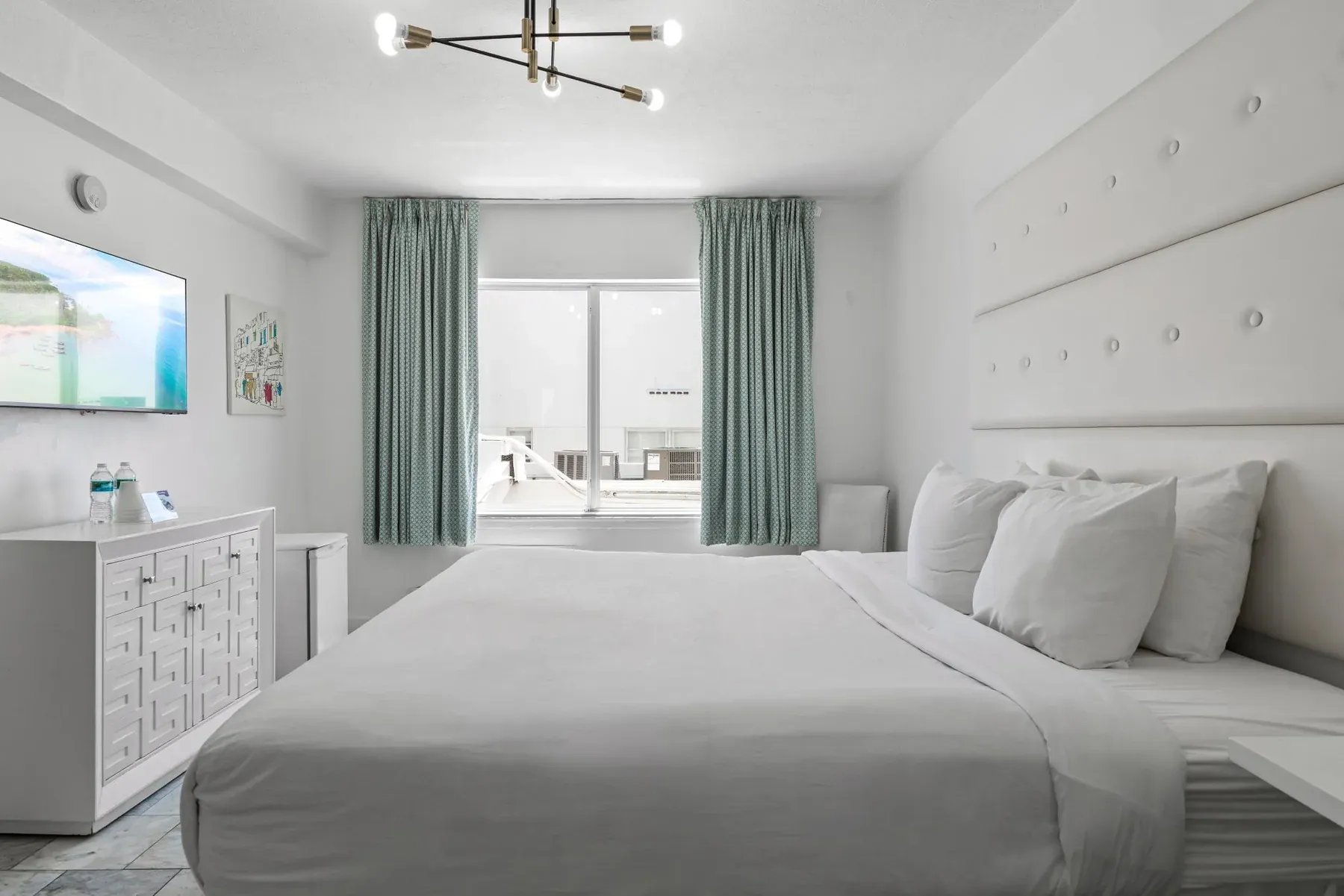 The king bed with the dresser and television opposite
