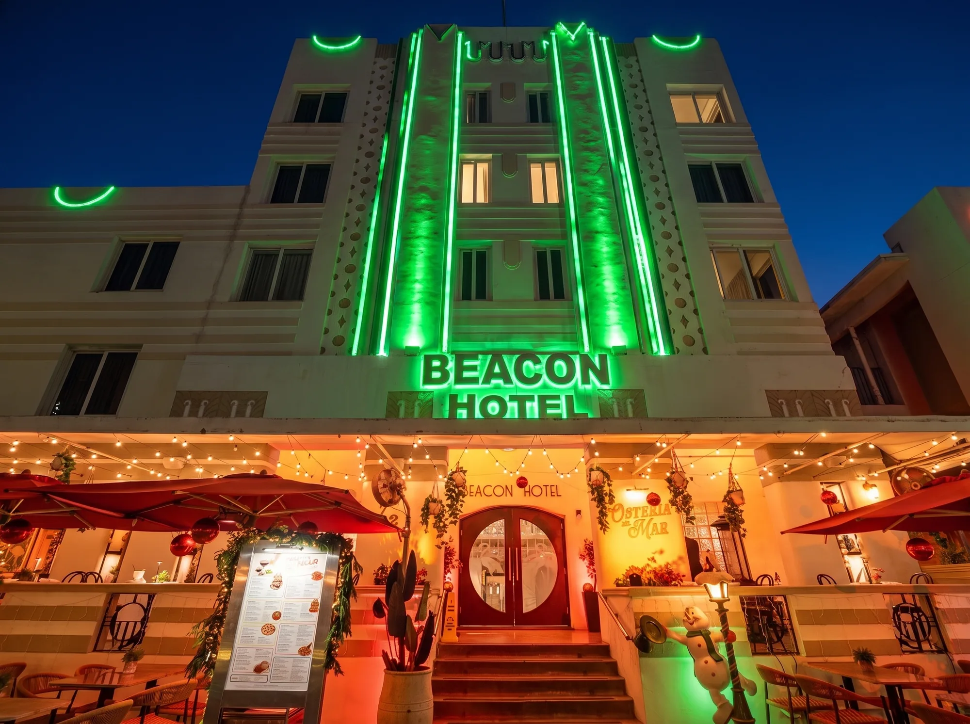 The Beacon’s facade at night, green neon above the entrance