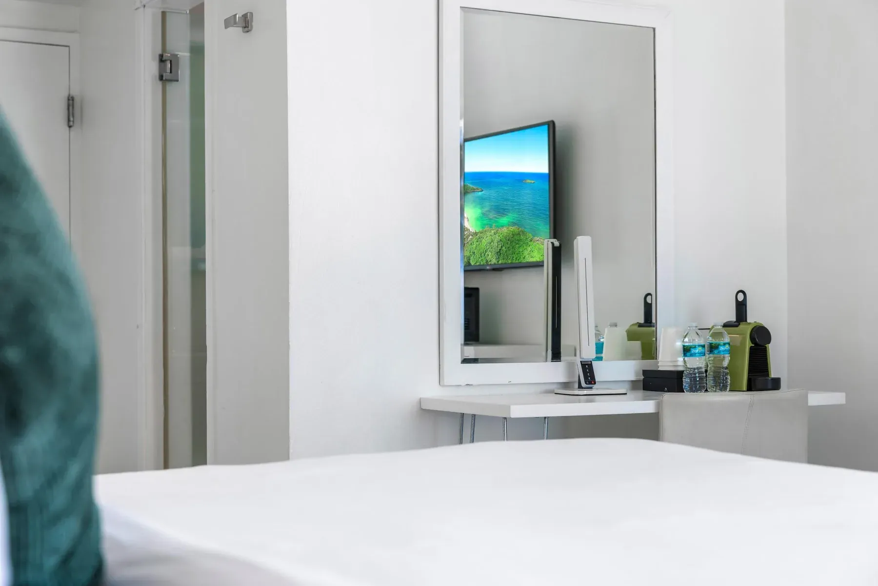 The television and dressing table across from the foot of the bed